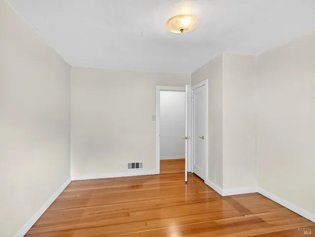 a view of an empty room with wooden floor
