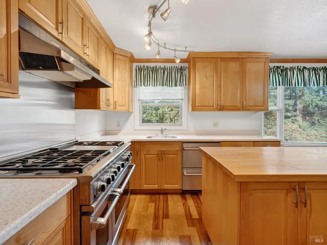 a kitchen with granite countertop a stove a sink and a microwave