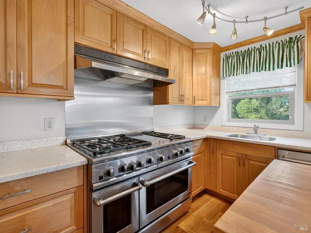 a kitchen with stainless steel appliances granite countertop a stove and a sink