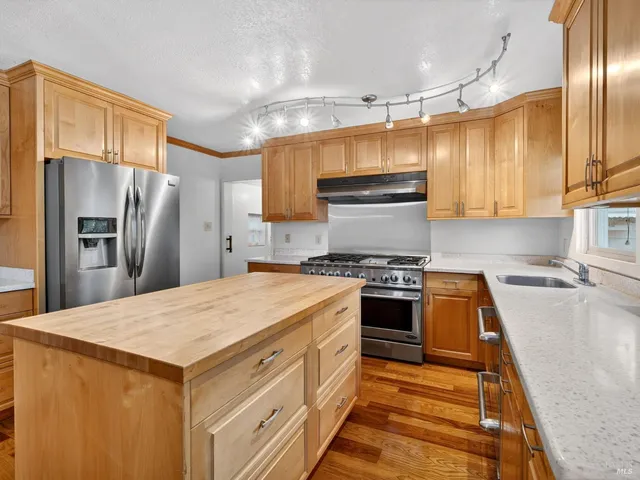 a kitchen with stainless steel appliances a refrigerator sink and stove