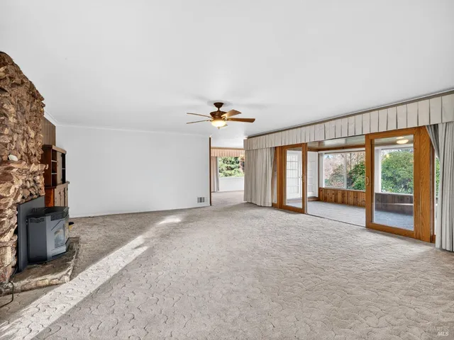 a view of an empty room with a fireplace and a large window