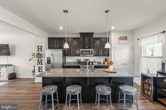 a kitchen with kitchen island a sink stove and wooden floor
