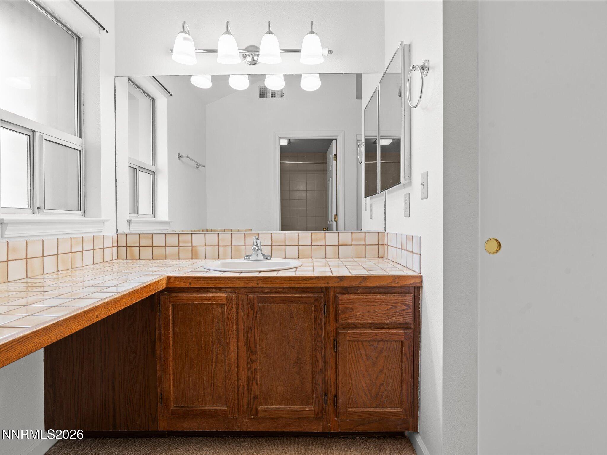 3170 Oakshire Court Reno, NV 89509 - Photo 27 of 43 a bathroom with a double vanity sink and a mirror