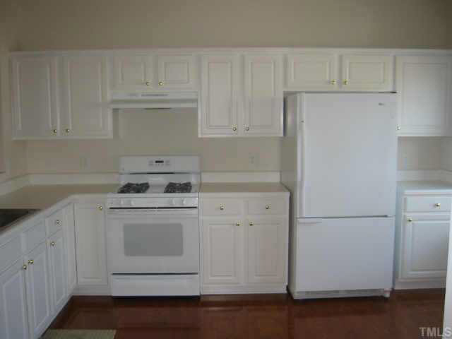 All white kitchen complements hardwood floors. Other