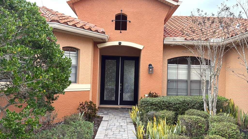 898 San Raphael Street Poinciana, FL 34759 - Photo 1 of 37 a front view of a house with garden