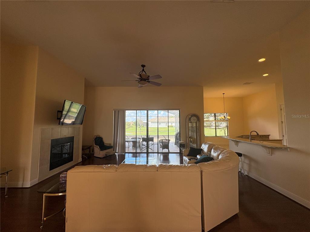898 San Raphael Street Poinciana, FL 34759 - Photo 12 of 37 a living room with furniture a flat screen tv and a fireplace