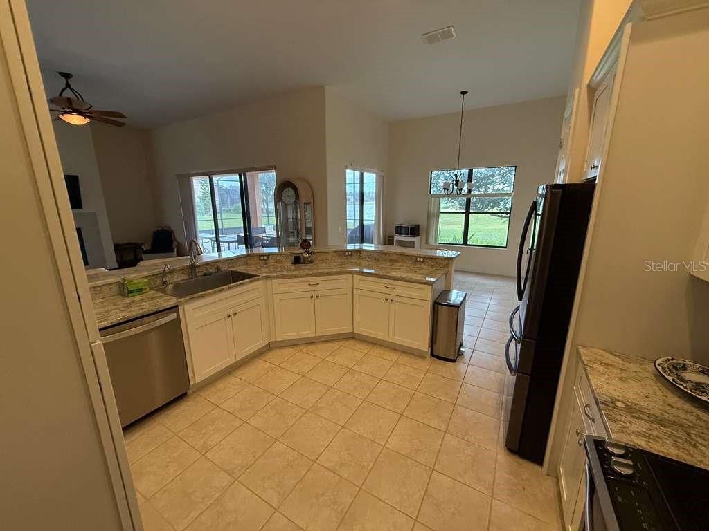 898 San Raphael Street Poinciana, FL 34759 - Photo 13 of 37 a kitchen with a sink a stove a refrigerator and furniture