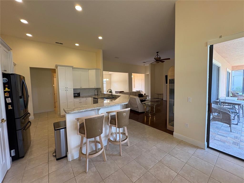 898 San Raphael Street Poinciana, FL 34759 - Photo 16 of 37 a kitchen with a sink refrigerator and cabinets