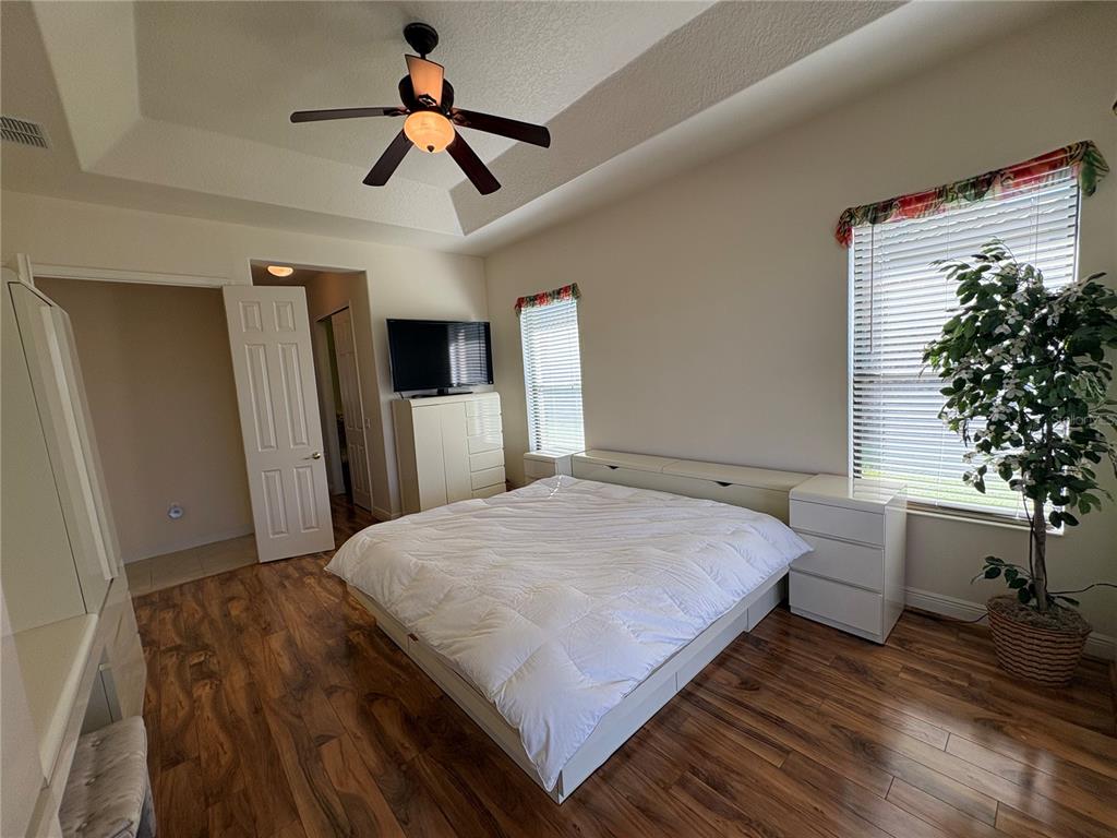 898 San Raphael Street Poinciana, FL 34759 - Photo 17 of 37 a bedroom with a bed and a chandelier