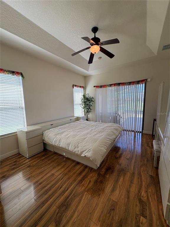 898 San Raphael Street Poinciana, FL 34759 - Photo 18 of 37 a bedroom with a bed and wooden floor