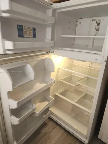 a kitchen with white cabinets and wooden floor
