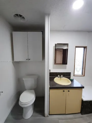 a bathroom with a toilet sink and mirror