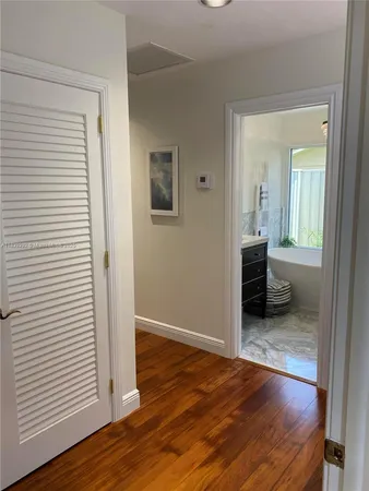 an empty room with wooden floor and a bathroom