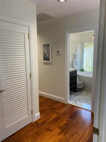 an empty room with wooden floor and a bathroom