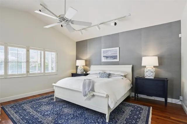 a large bedroom with a bed and wooden floor