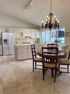 a kitchen with a stove a sink a counter space dining table and chairs