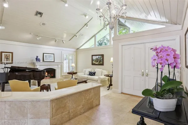 a living room with furniture a chandelier and a fireplace