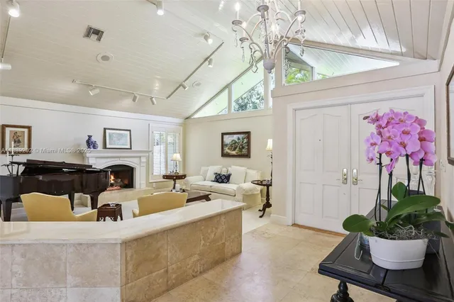 a living room with furniture a chandelier and a fireplace