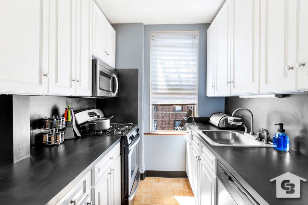7201 4th Avenue, Unit D2 Brooklyn, NY 11209 - Photo 2 of 6 a kitchen with a sink a stove and cabinets