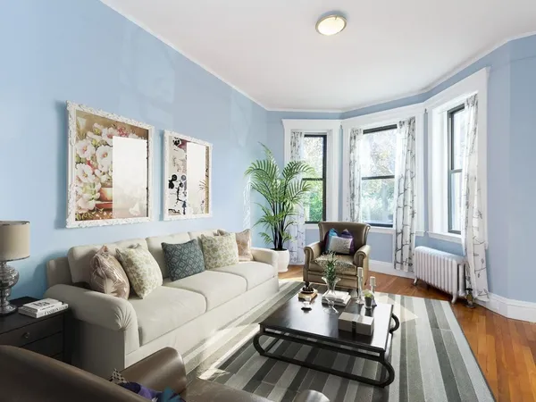 a living room with furniture wooden floor and a large window