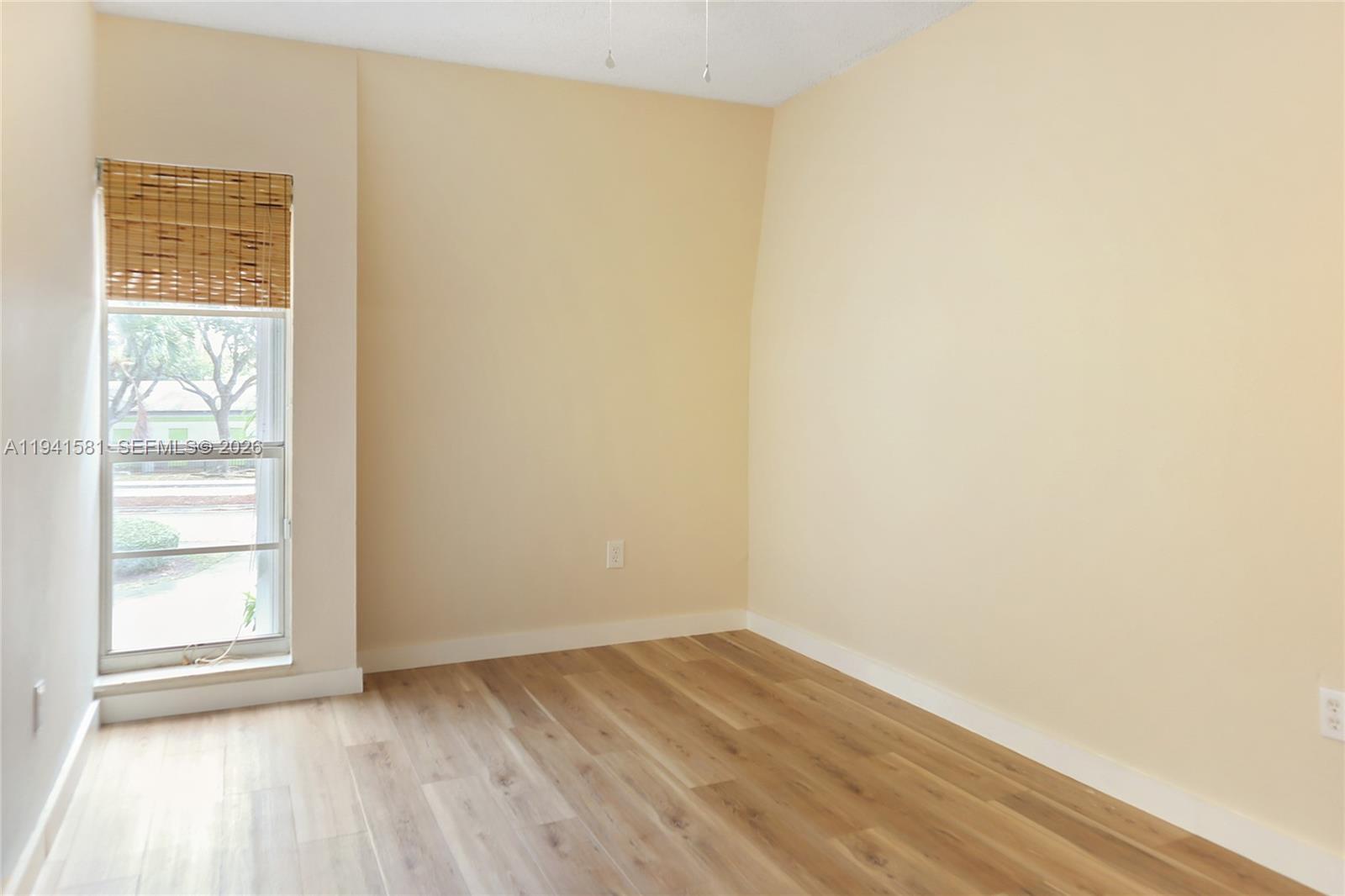 14009 Southwest 84th Street Miami, FL 33183 - Photo 14 of 15 a view of an empty room with wooden floor and a window