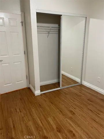 an empty room with wooden floor and a window