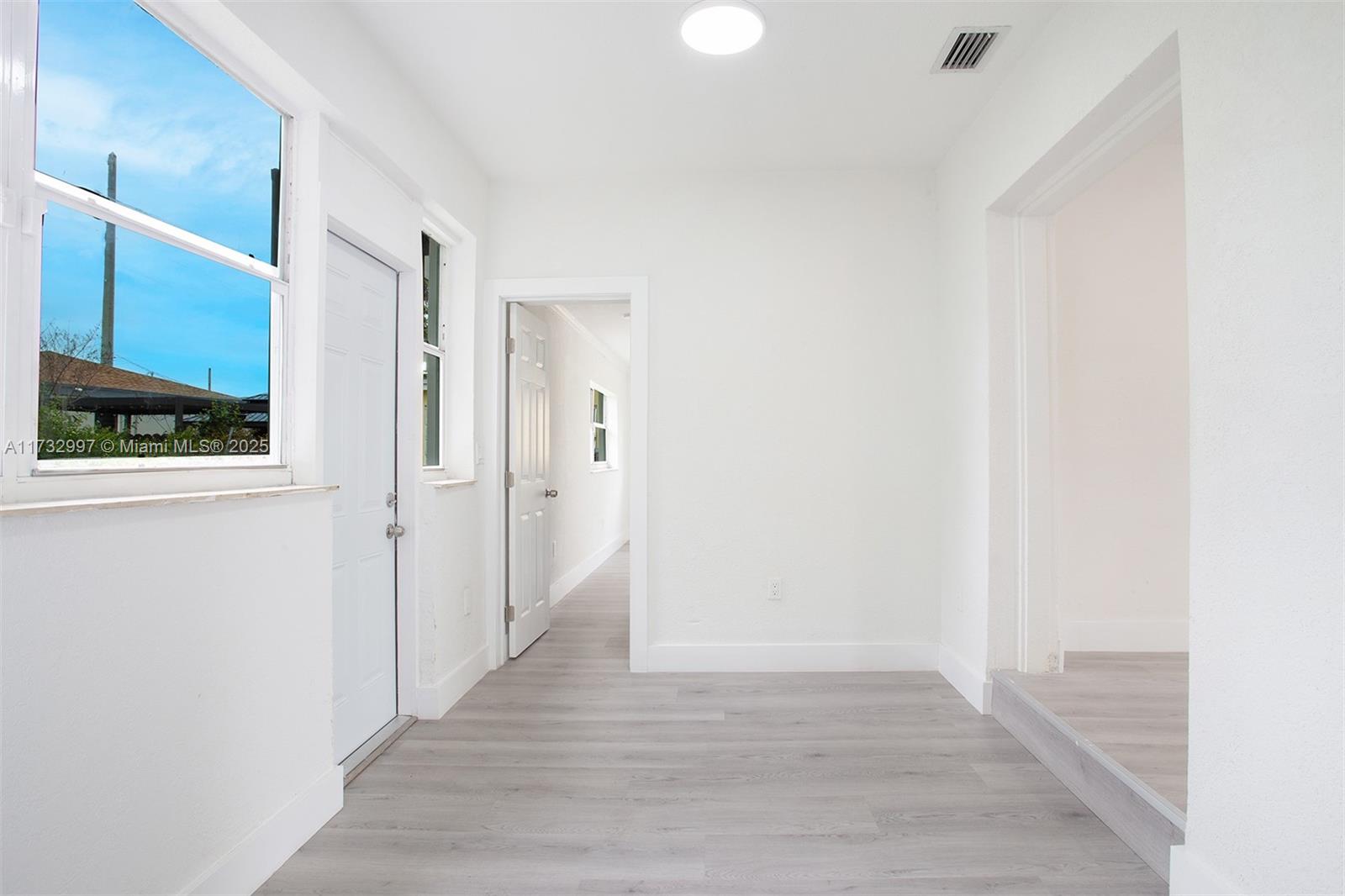 1923 Northwest 66th Street Miami, FL 33147 - Photo 11 of 29 a view of a hallway with wooden floor and staircase