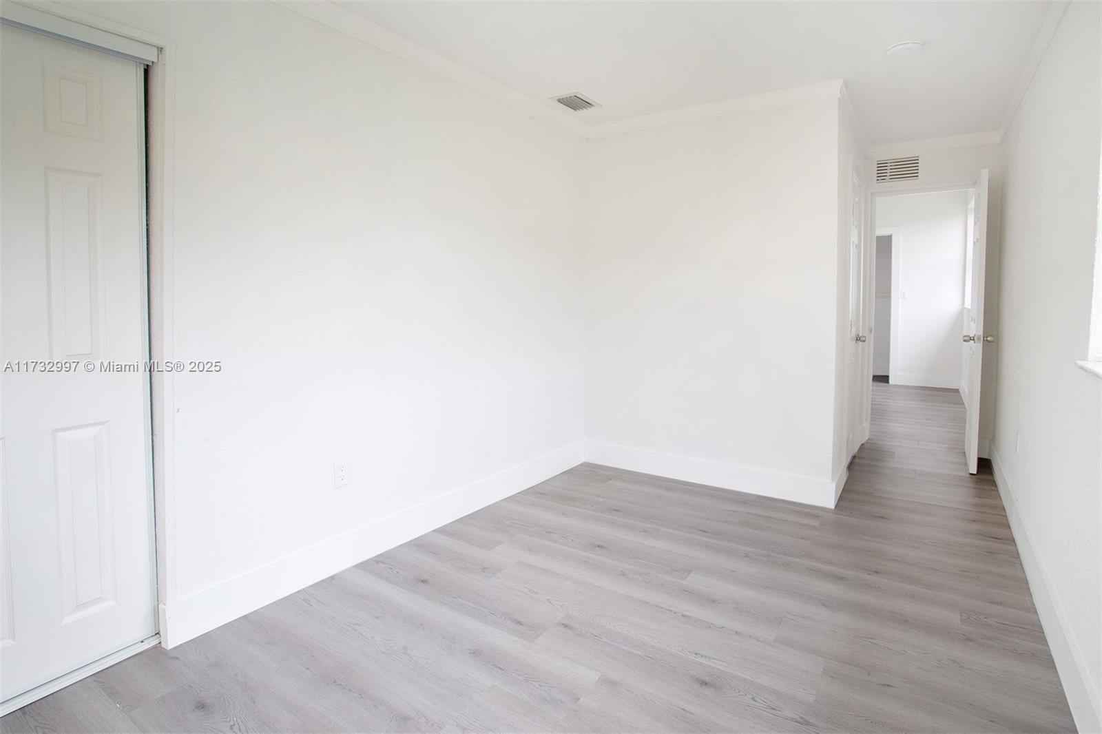 1923 Northwest 66th Street Miami, FL 33147 - Photo 14 of 29 a view of an empty room with wooden floor
