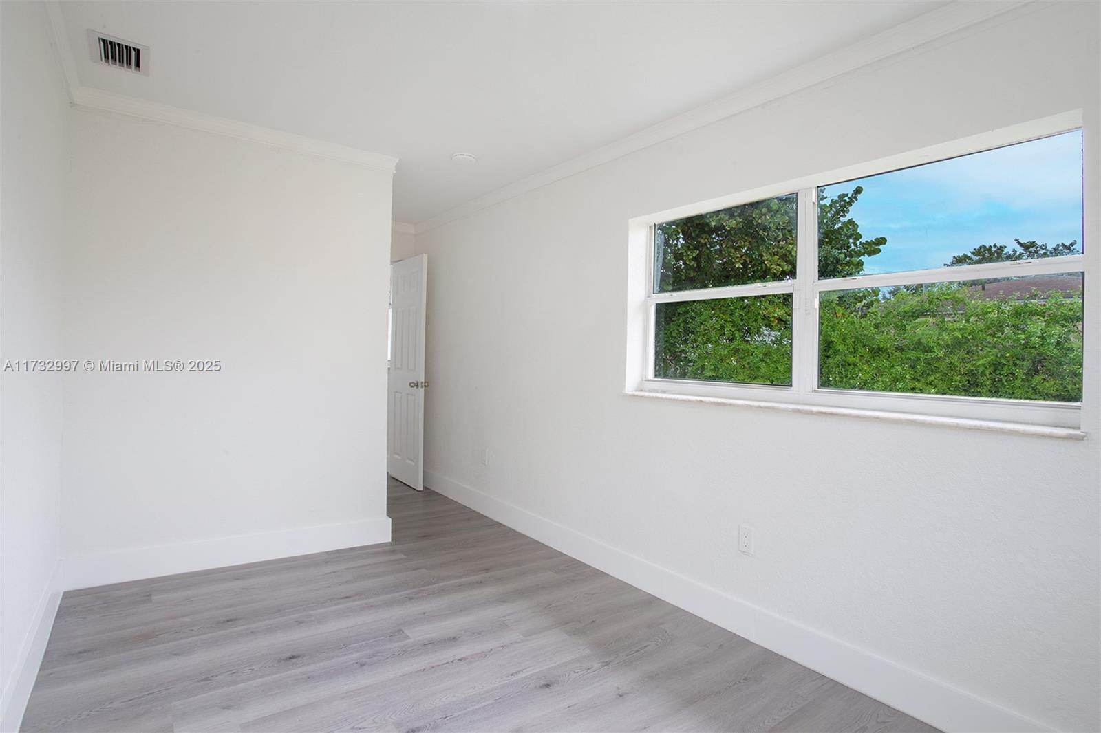 1923 Northwest 66th Street Miami, FL 33147 - Photo 15 of 29 an empty room with wooden floor and windows