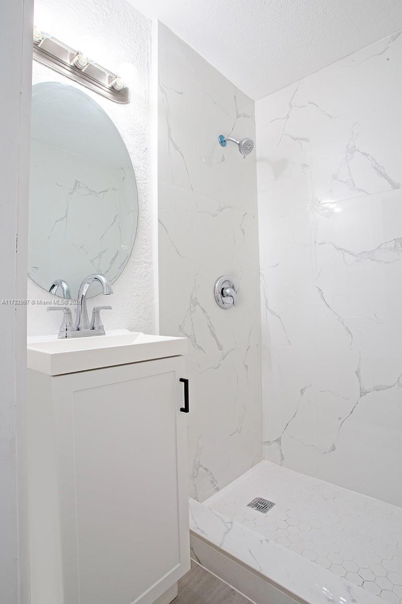 1923 Northwest 66th Street Miami, FL 33147 - Photo 16 of 29 a bathroom with a sink a mirror and shower