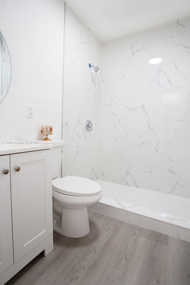1923 Northwest 66th Street Miami, FL 33147 - Photo 23 of 29 a bathroom with a toilet a sink a shower and mirror