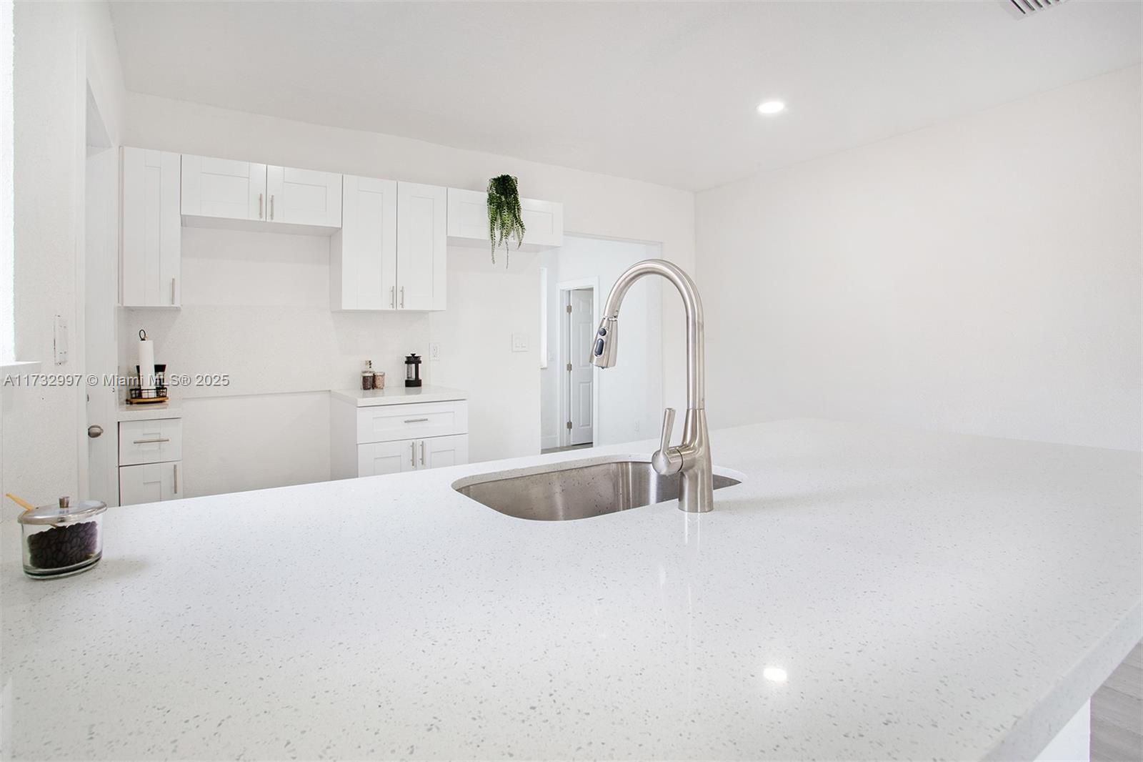 1923 Northwest 66th Street Miami, FL 33147 - Photo 8 of 29 a kitchen with white cabinets a sink and dishwasher