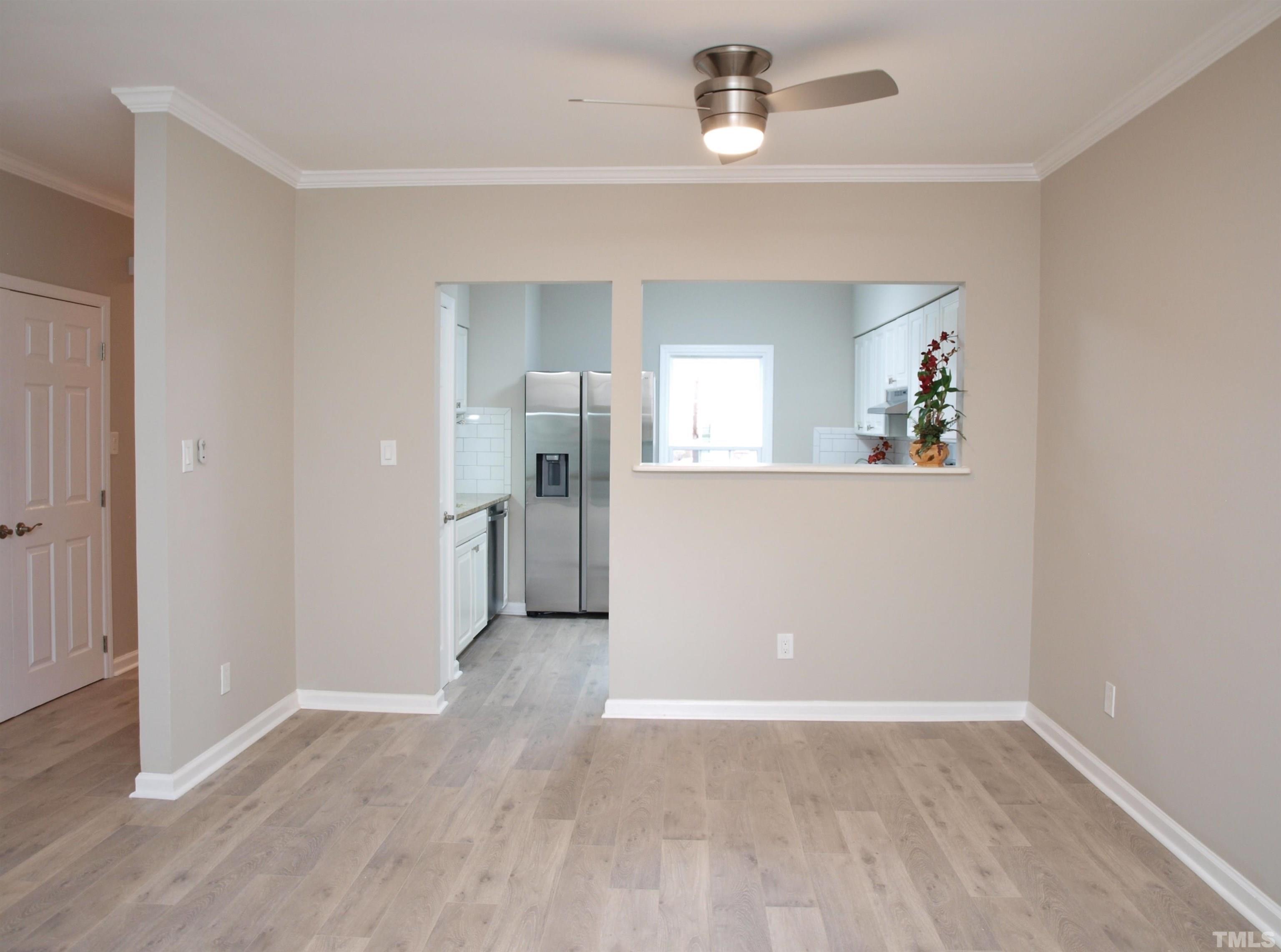 6123 Bushmills Street Raleigh, NC 27613 - Photo 3 of 16 an empty room with wooden floor and mirror