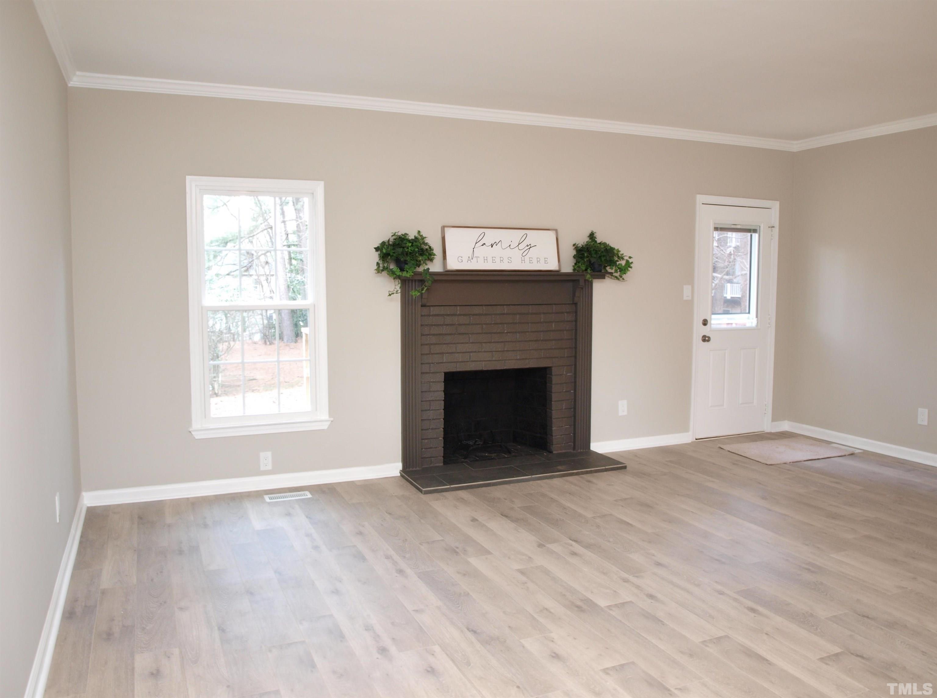 6123 Bushmills Street Raleigh, NC 27613 - Photo 9 of 16 a view of empty room with wooden floor and fireplace