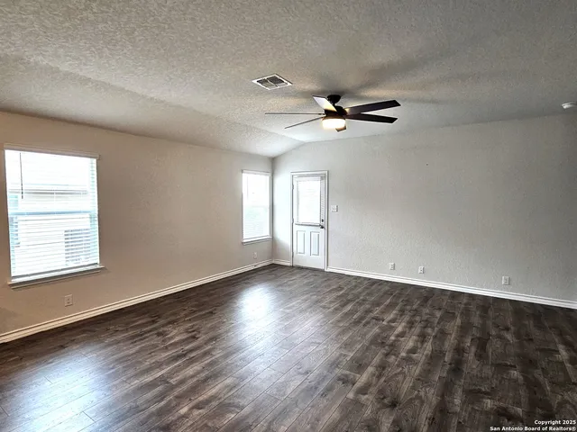 a view of empty room with wooden floor