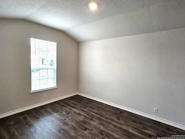 a view of a kitchen with wooden floor and a hallway