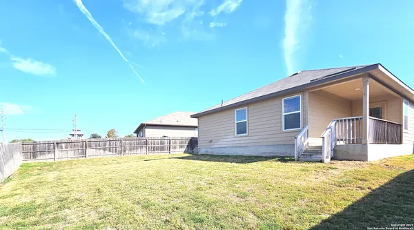a view of a house with backyard and patio