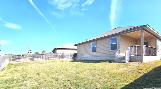 a view of a house with backyard and patio
