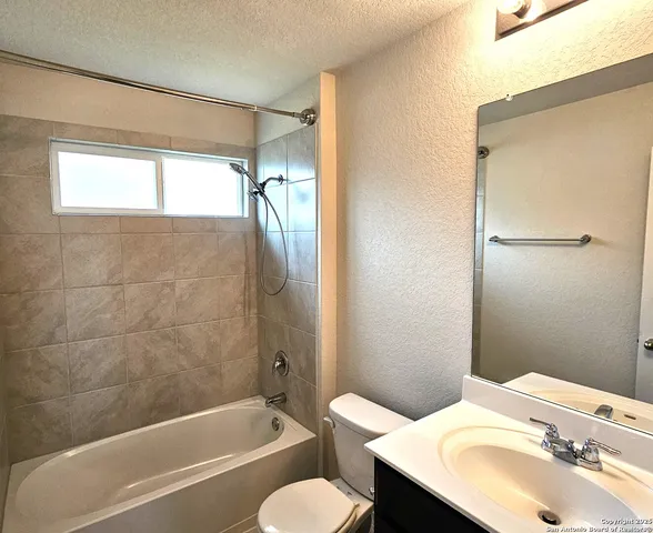 a bathroom with a bathtub shower sink and mirror
