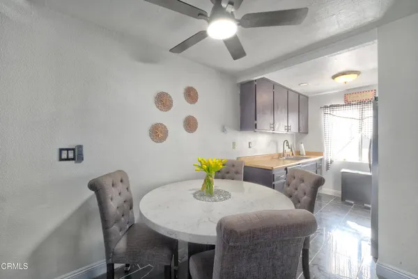 a kitchen with stainless steel appliances kitchen island granite countertop a sink a stove a dining table and chairs