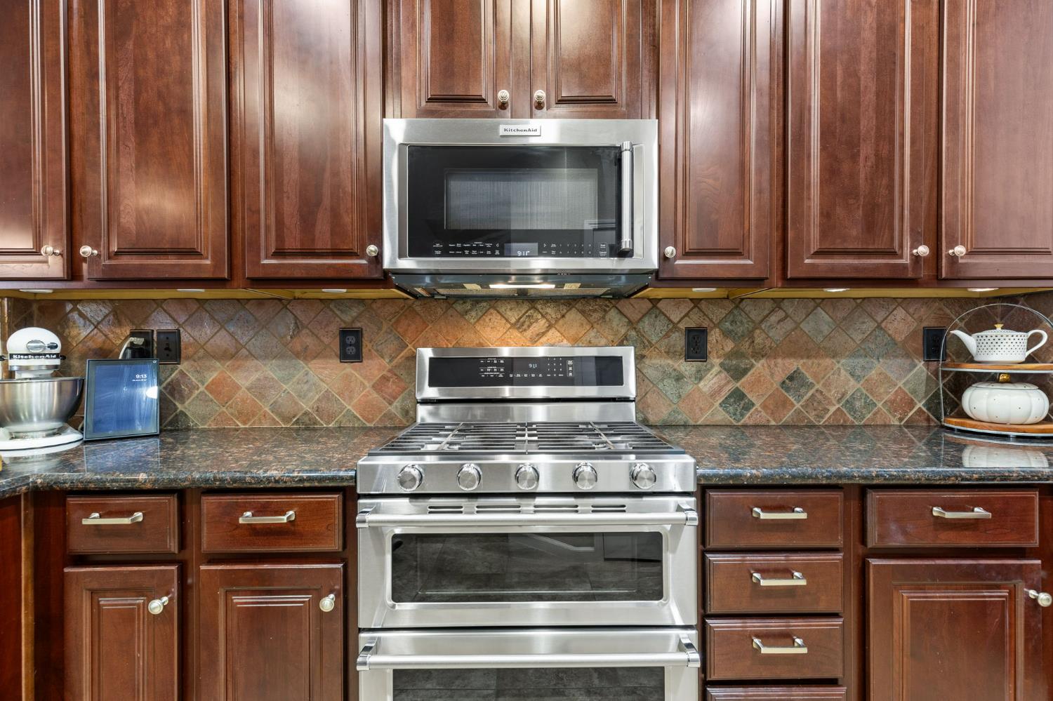 1107 Hudson Circle Lincoln, CA 95648 - Photo 17 of 51 a kitchen with granite countertop stainless steel appliances a stove microwave and sink