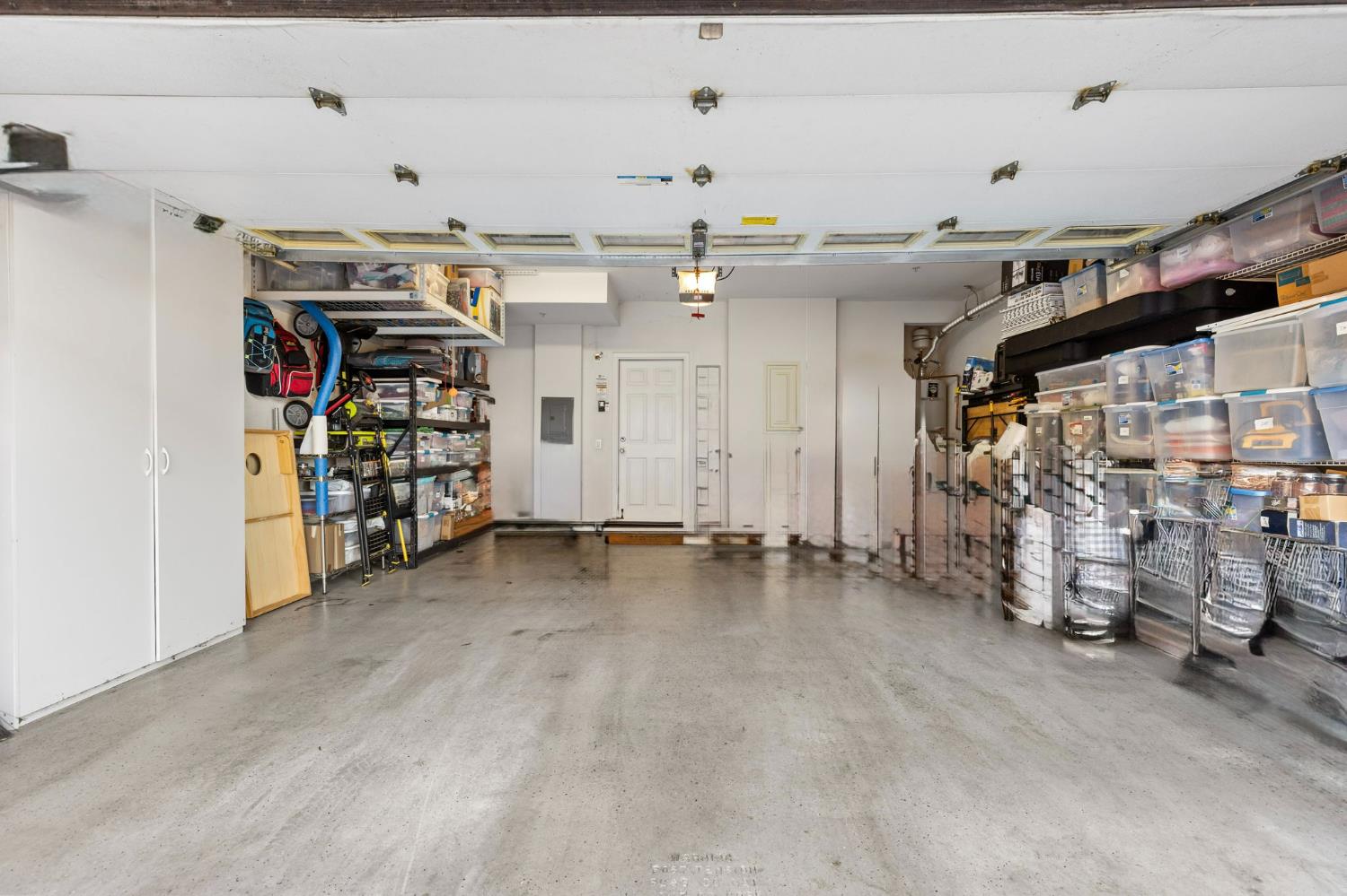 1107 Hudson Circle Lincoln, CA 95648 - Photo 41 of 51 Two-car garage includes overhead storage racks, white wire shelving on the right side, and two white storage cabinets. (Photo was digitally cleaned up of some personal items)