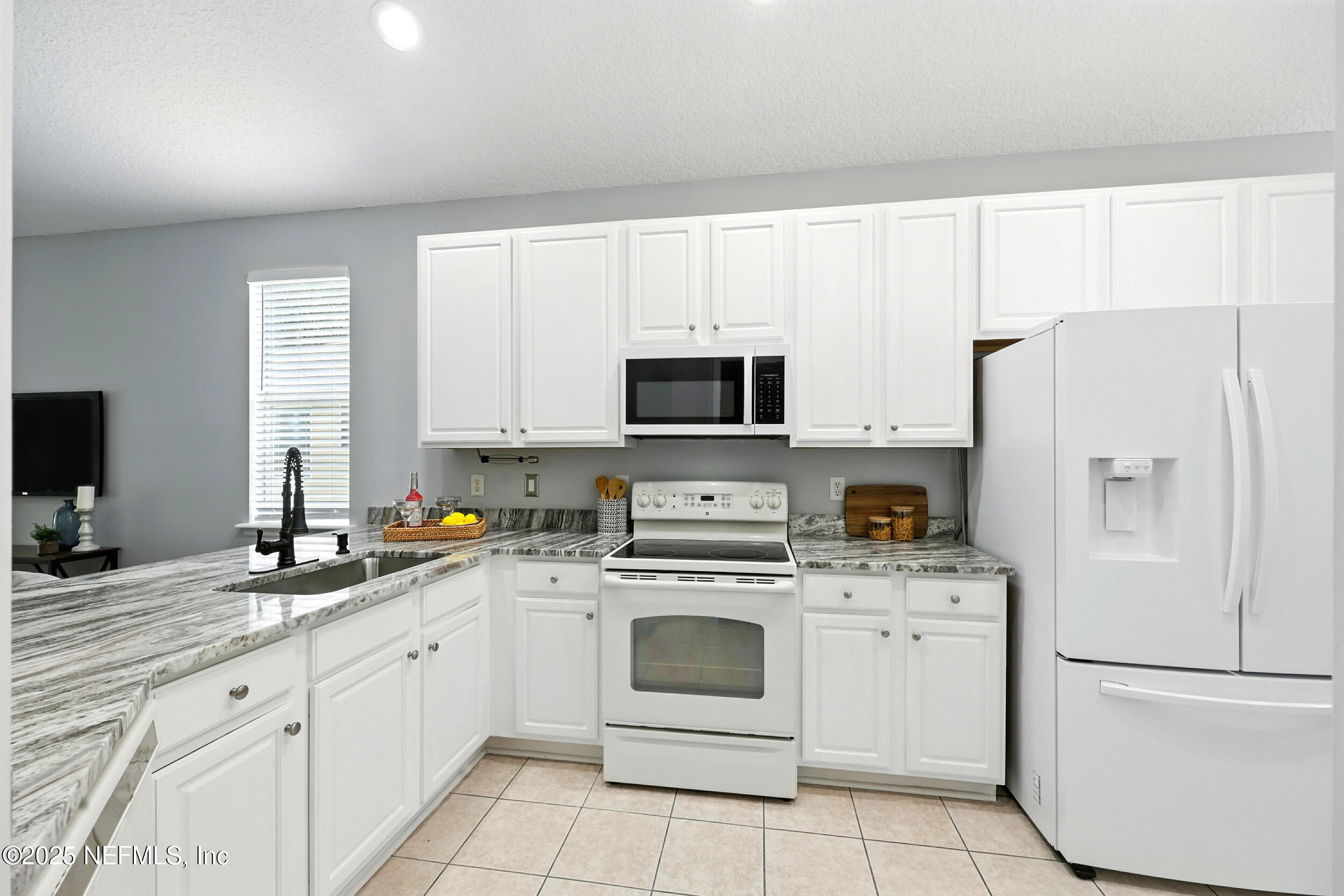 778 Copperhead Circle St. Augustine, FL 32092 - Photo 5 of 43 a kitchen with white cabinets sink and white appliances