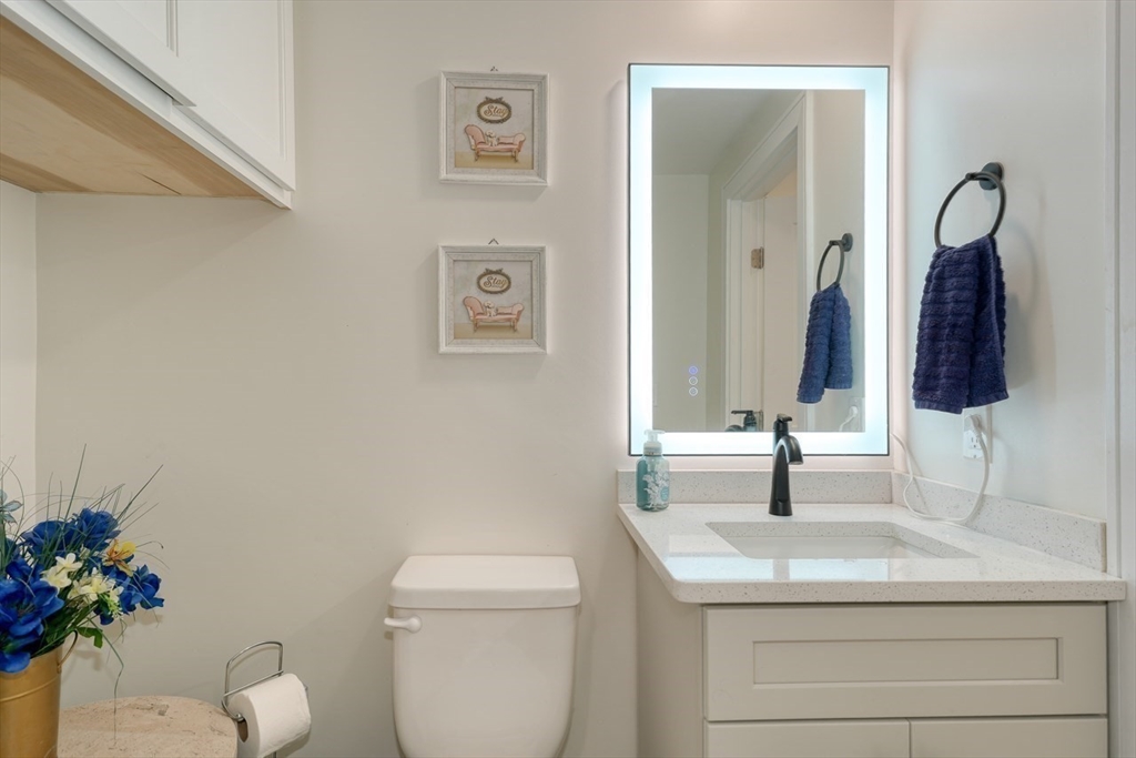 17 School Street, Unit A Hudson, MA 01749 - Photo 13 of 19 a bathroom with a toilet sink and mirror