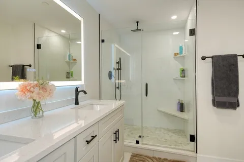 a bathroom with a shower sink and mirror