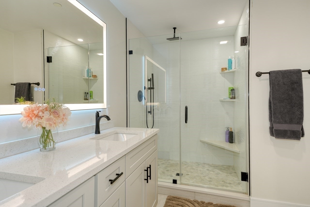 17 School Street, Unit A Hudson, MA 01749 - Photo 9 of 19 a bathroom with a shower sink and mirror