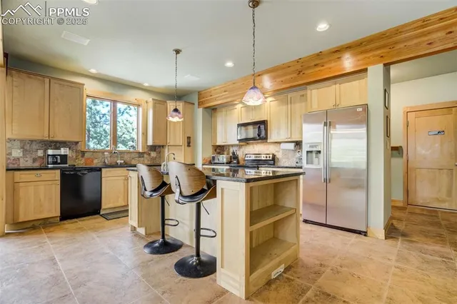 a kitchen with kitchen island a counter top space a sink cabinets and stainless steel appliances