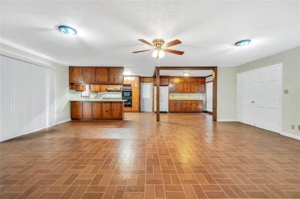 2058 Graham Road Macon, GA 31211 - Photo 10 of 37 a view of a kitchen with a stove cabinets a ceiling fan and wooden floor