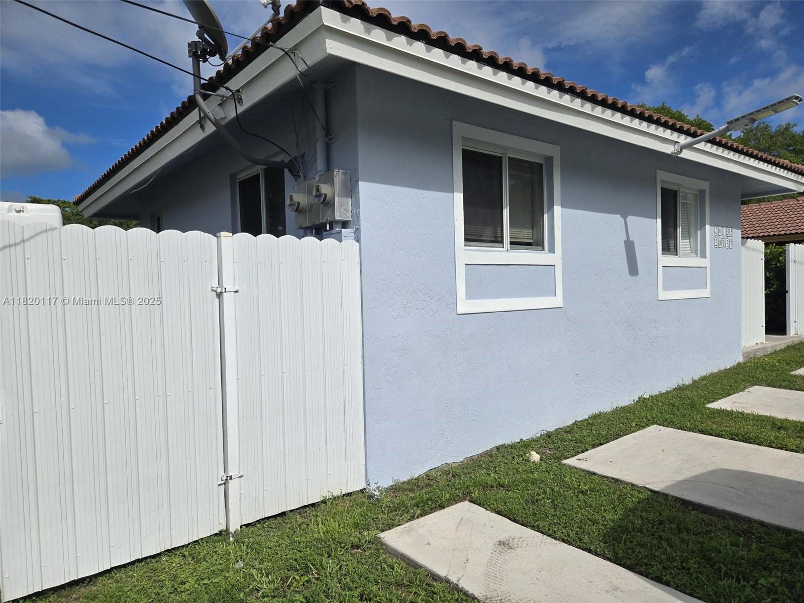 20137 Southwest 88th Court, Unit 20135 Cutler Bay, FL 33189 - Photo 27 of 33 a house with white door of house next to a yard