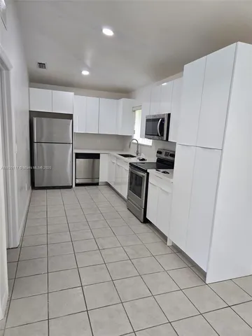 a kitchen with stainless steel appliances a refrigerator sink and cabinets